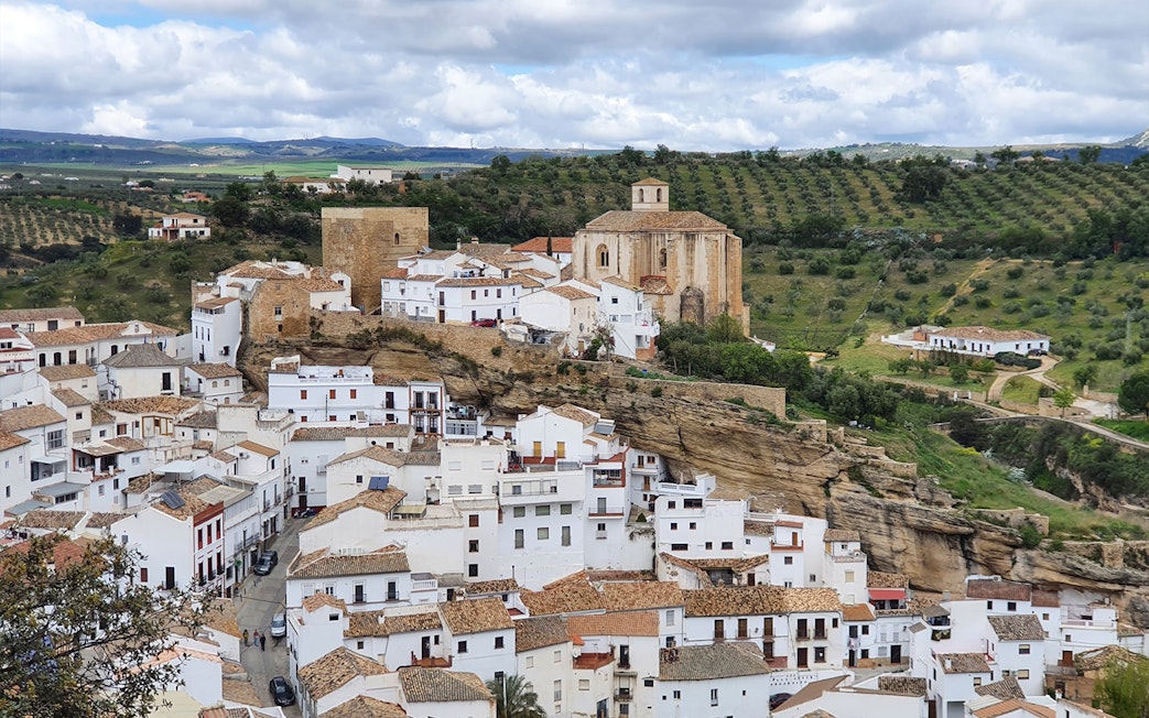 Setenil de las Bodegas village with cliffside houses and church, Spain.