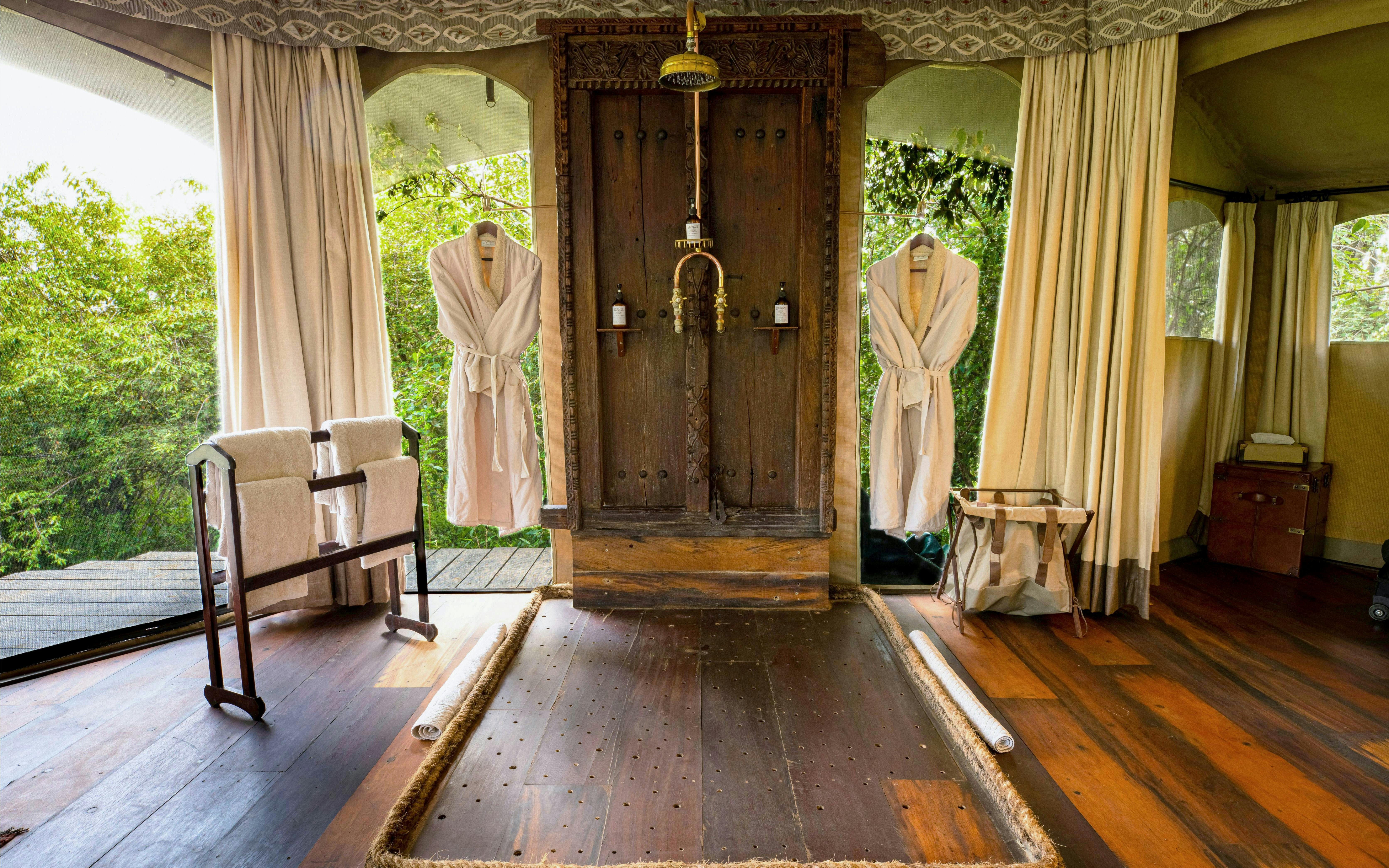 Luxury lodge room interior with wooden shower, robes, and towels, Olare Motorogi Conservancy, Kenya.