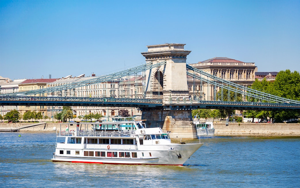 Cruise ship on Danube River passing under Chain Bridge in Budapest.