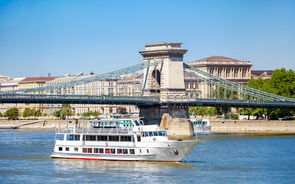 Cruise ship on Danube River passing under Chain Bridge in Budapest.