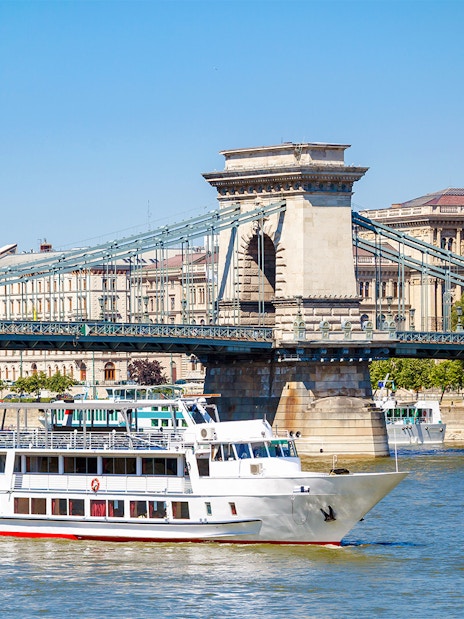 Cruise ship on Danube River passing under Chain Bridge in Budapest.