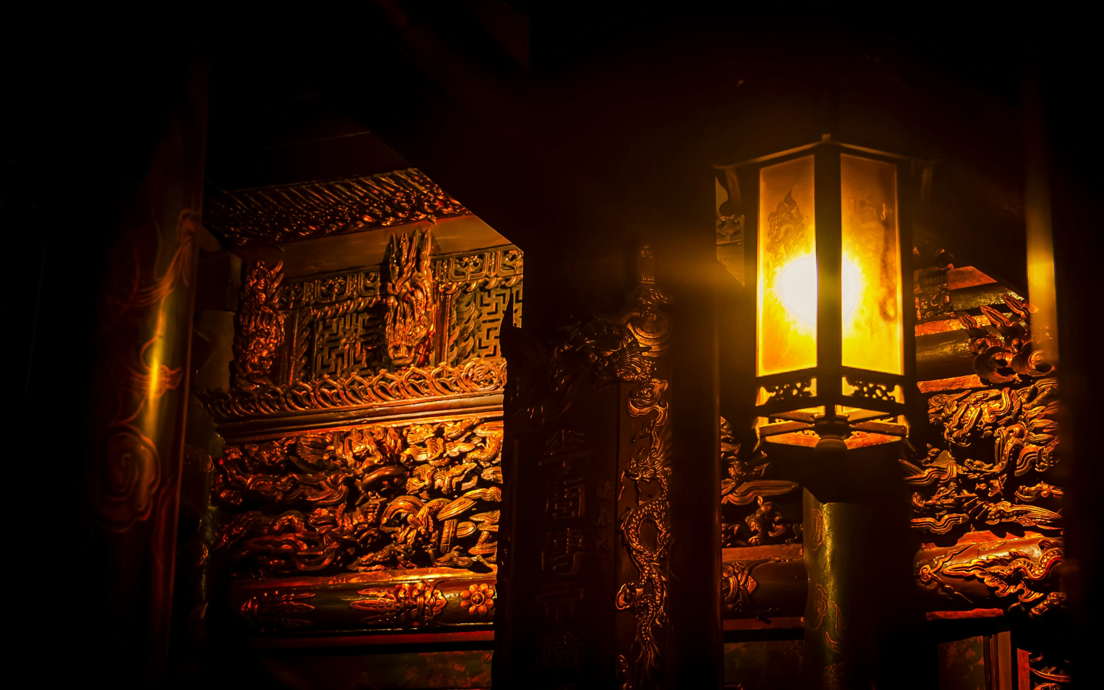 Lantern illuminating intricate carvings at King Temple, Hoa Lu, Ninh Binh, Vietnam.