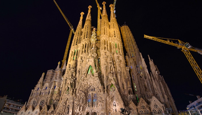 Night view of the illuminated Nativity Façade of Sagrada Familia in Barcelona.