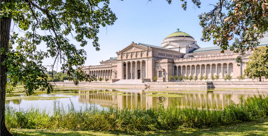 Grand building with columns and dome by a pond, Museum of Science, Boston.