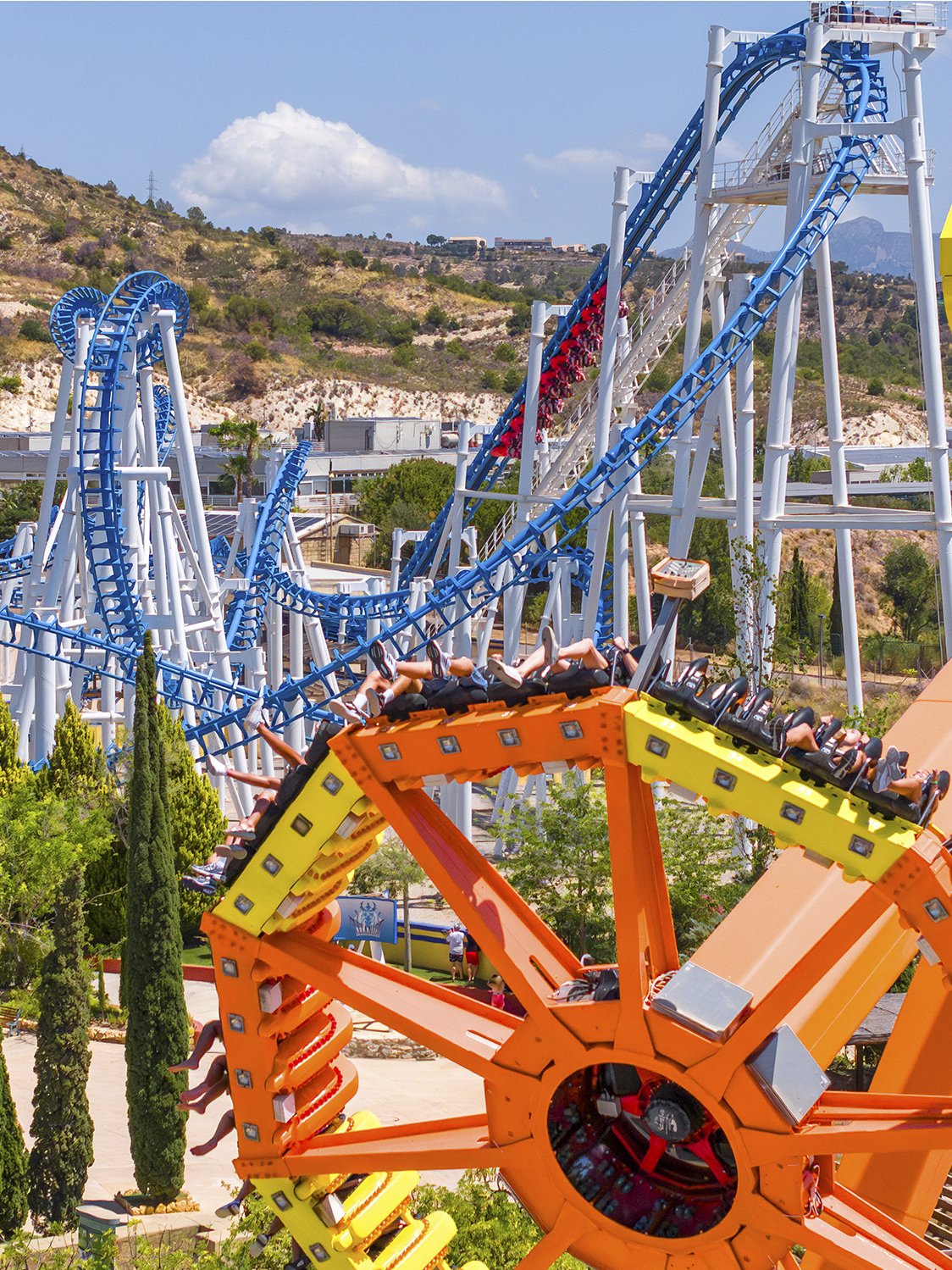 Roller coaster and spinning ride at Terra Mitica theme park, Benidorm, Spain.