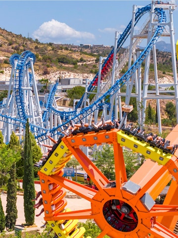 Roller coaster and spinning ride at Terra Mitica theme park, Benidorm, Spain.