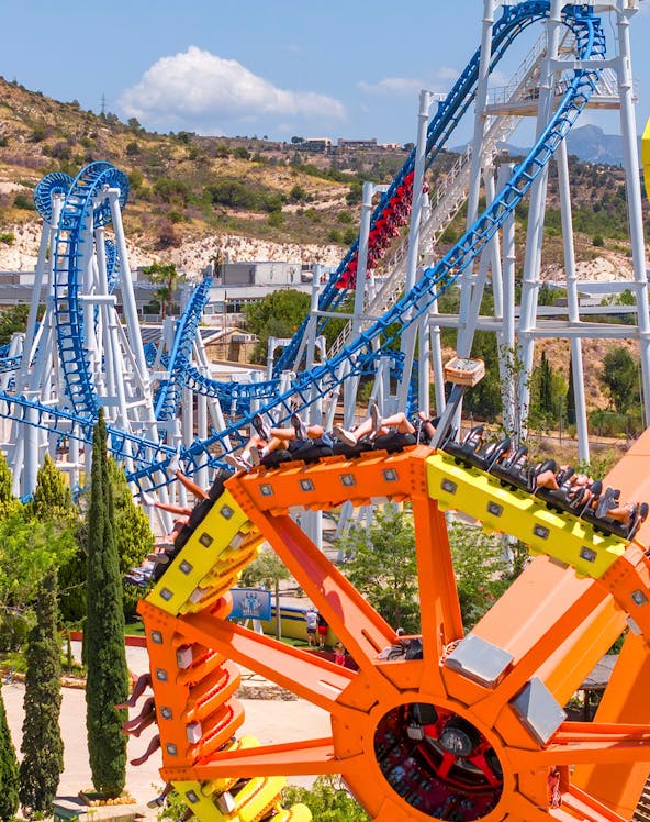 Roller coaster and spinning ride at Terra Mitica theme park, Benidorm, Spain.