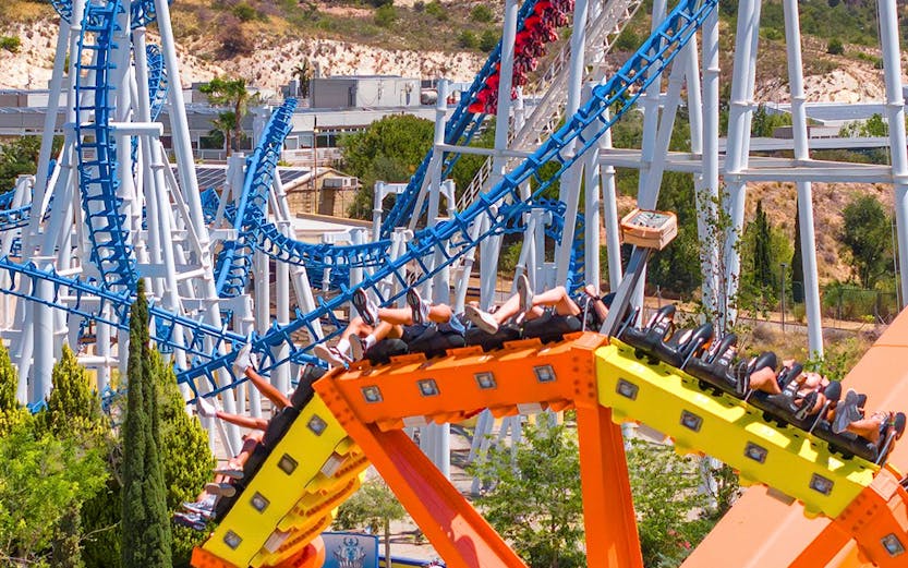 Roller coaster and spinning ride at Terra Mitica theme park, Benidorm, Spain.