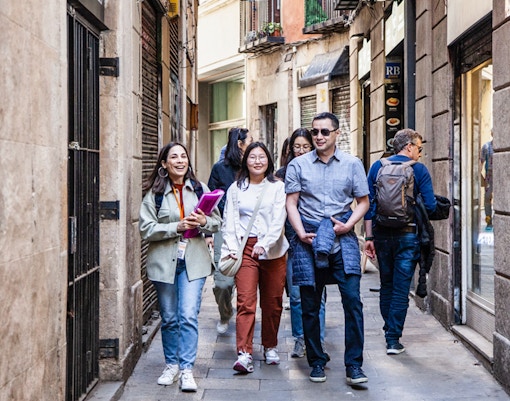 Tourists walking through Barcelona streets near Picasso Museum.