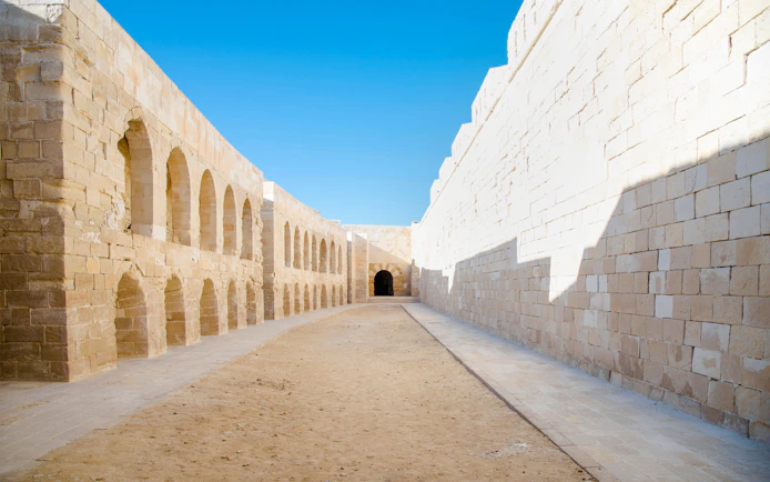 Street inside Qaitbay Citadel, Alexandria, Egypt, with stone walls and arches.