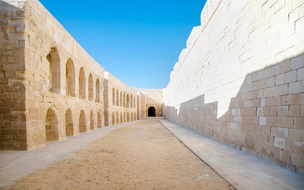 Street inside Qaitbay Citadel, Alexandria, Egypt, with stone walls and arches.