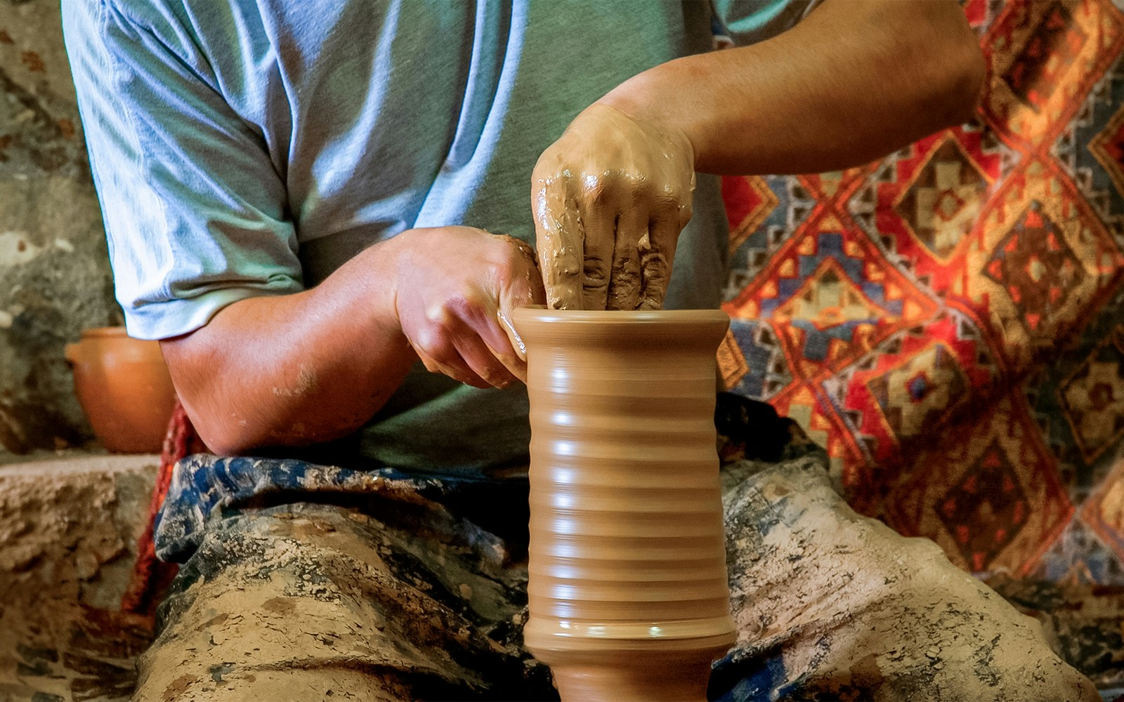 Potter shaping clay on a wheel