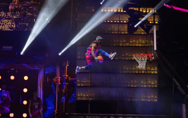 Performer dunking basketball during Mad Apple show in New York City.