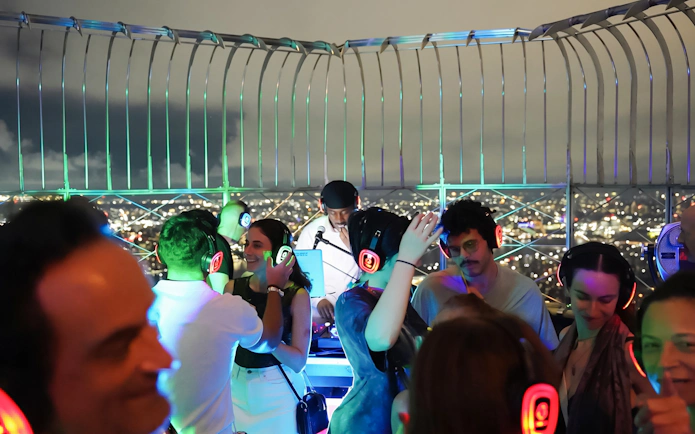 Silent disco on Empire State Building Observation Deck with city lights in background.