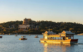 Boats on Kunming Lake with Summer Palace in Beijing during a day tour.