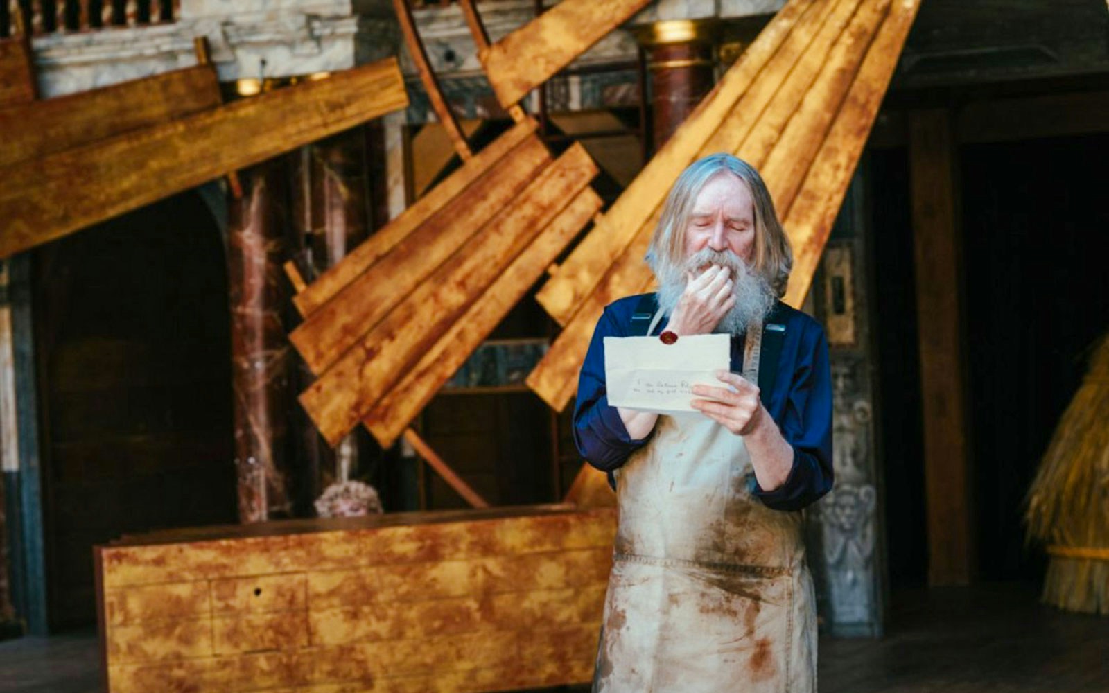 Actor reading letter on stage during "Twelfth Night" performance.