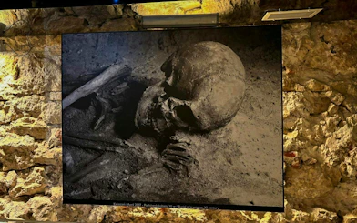 Burial exhibit at Rynek Underground Museum, Krakow, featuring ancient human remains.