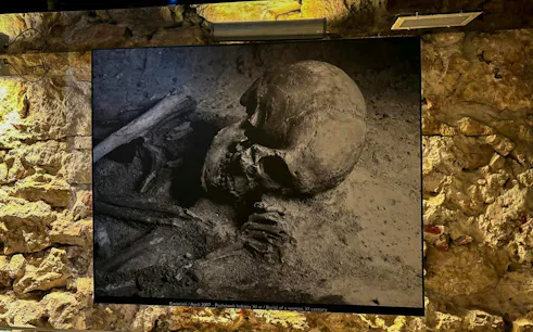 Burial exhibit at Rynek Underground Museum, Krakow, featuring ancient human remains.