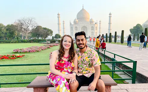 Couple sitting in front of the Taj Mahal during a private same-day tour from Delhi to Agra.