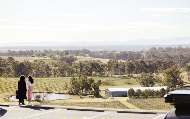 Hunter Valley vineyard view with two people overlooking the landscape.