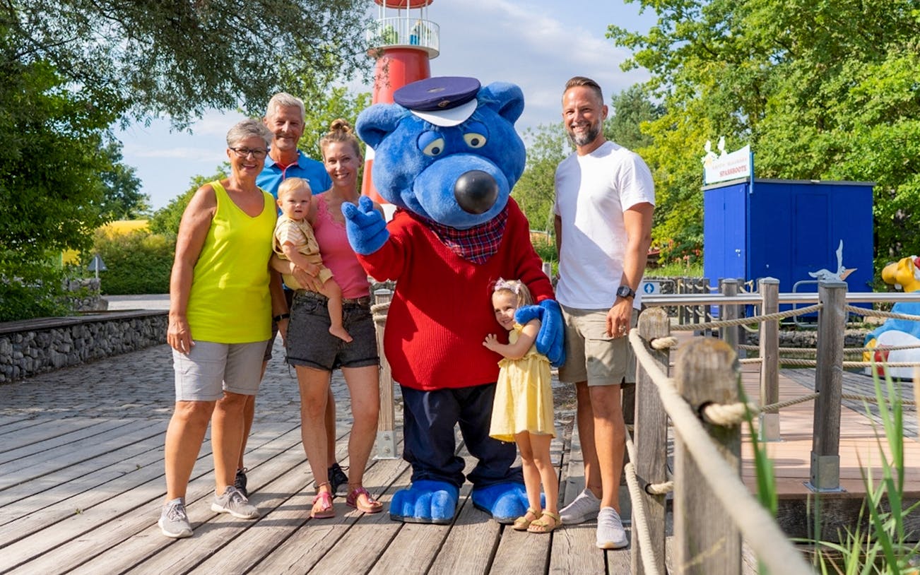 Family with mascot at Ravensburger Spieleland.