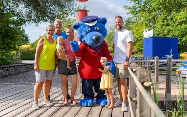 Family with mascot at Ravensburger Spieleland.