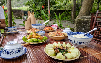 Traditional Vietnamese meal on a bamboo table in Ninh Binh during Tam Coc Pedal & Paddle tour.