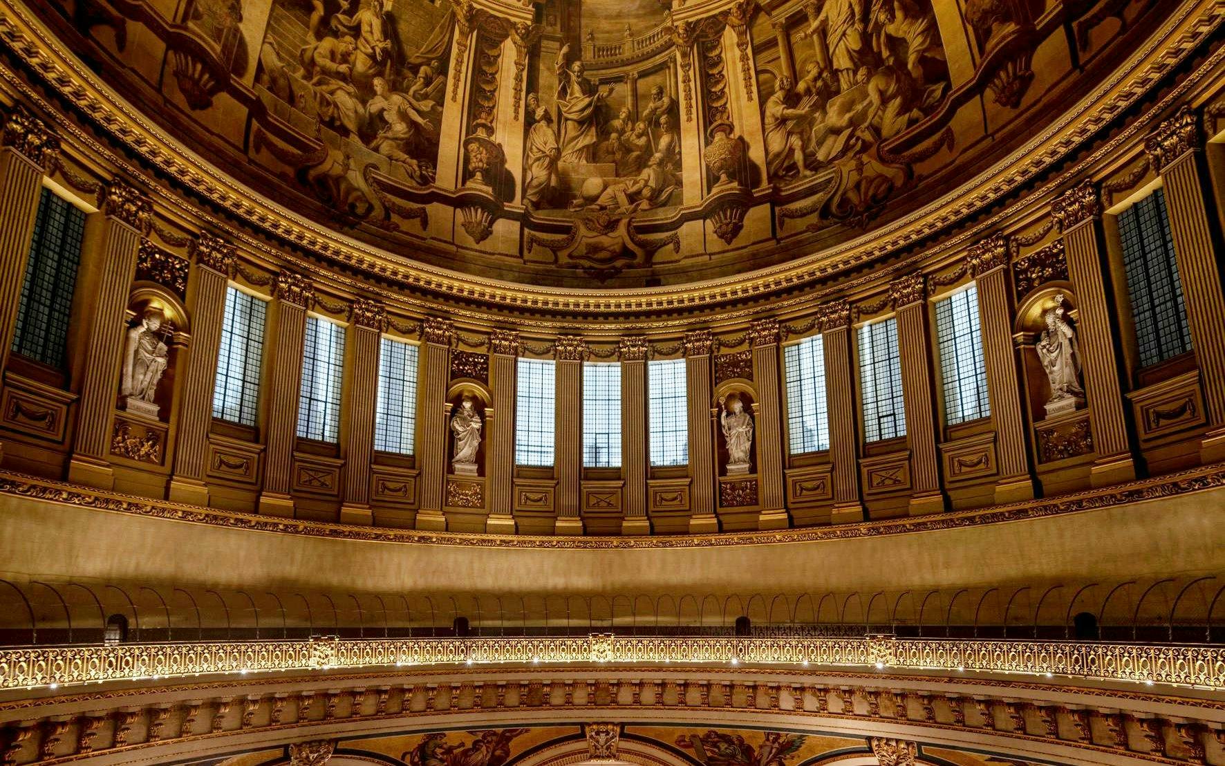 Interior dome of St Paul's Cathedral with ornate sculptures and detailed frescoes.