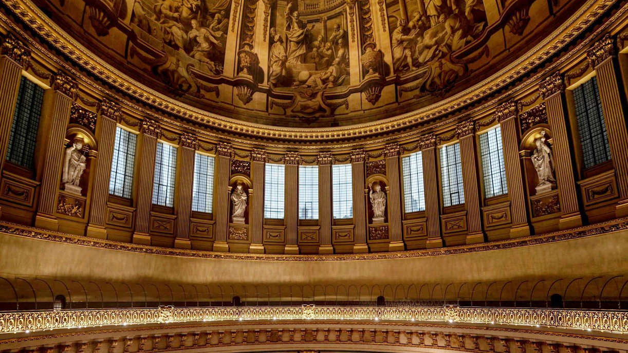 Interior dome of St Paul's Cathedral with ornate sculptures and detailed frescoes.