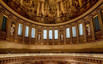 Interior dome of St Paul's Cathedral with ornate sculptures and detailed frescoes.