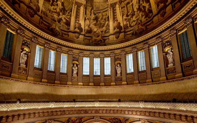 Interior dome of St Paul's Cathedral with ornate sculptures and detailed frescoes.