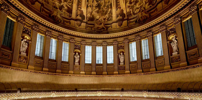Interior dome of St Paul's Cathedral with ornate sculptures and detailed frescoes.