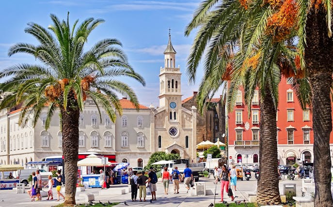 Riva Promenade with palm trees and historic buildings near Diocletian's Palace, Split, Croatia.