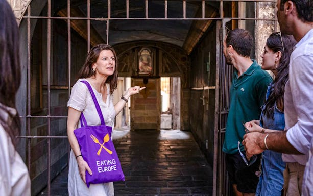 Guide leading a group through a hidden passage on a Rome food tour.