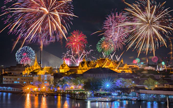Fireworks over Bangkok's Grand Palace at night, highlighting Promotion Group Saver Pack.