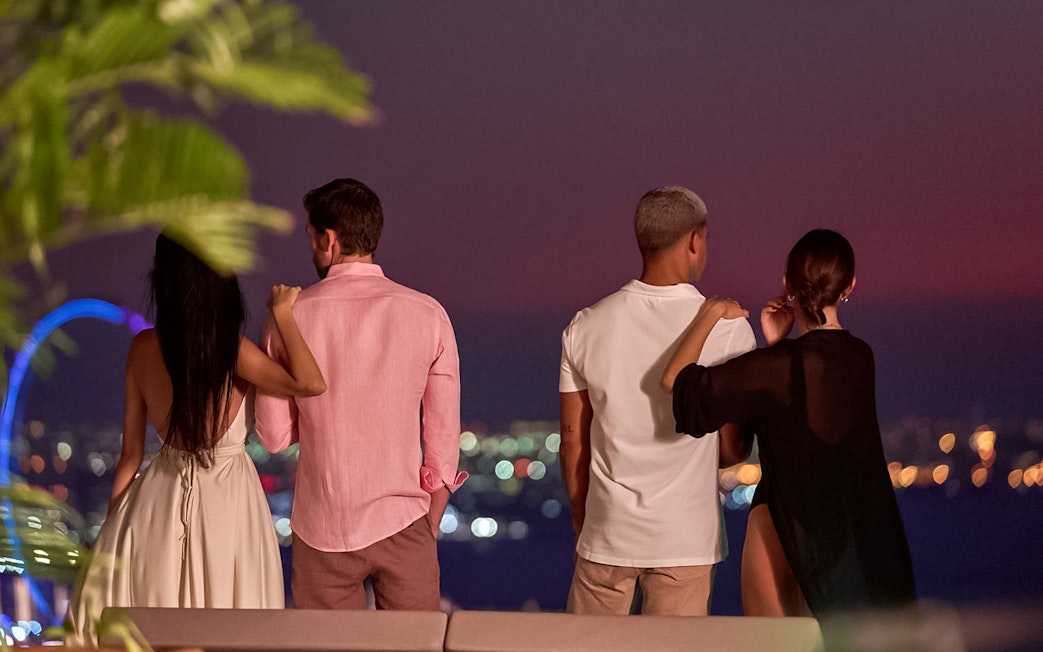 Tourists enjoying Palm Jumeirah view from Aura Sky Pool, Dubai.