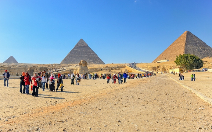 Visitors walking near the Pyramids of Giza and the Sphinx in Egypt.