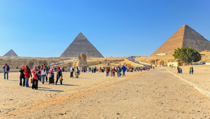 Visitors walking near the Pyramids of Giza and the Sphinx in Egypt.