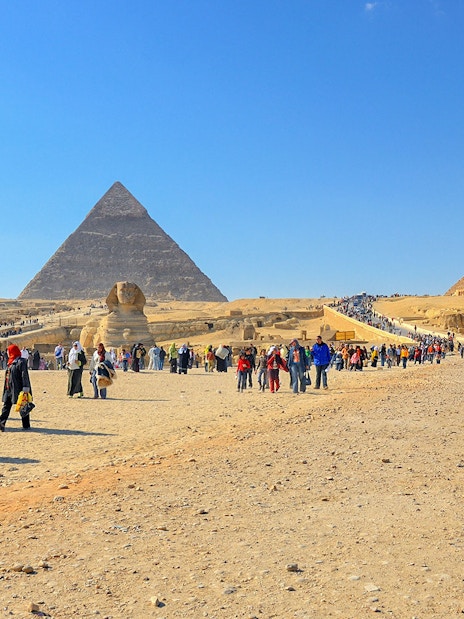 Visitors walking near the Pyramids of Giza and the Sphinx in Egypt.