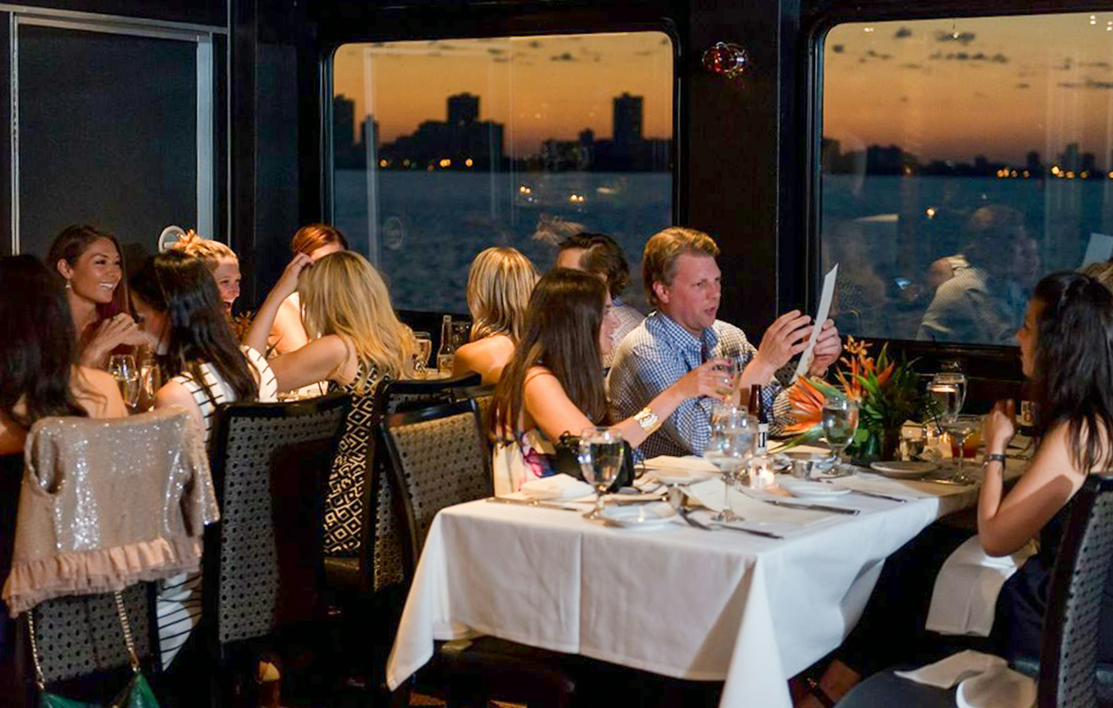 Guests dining on Odyssey Lake Michigan Dinner Cruise at sunset.
