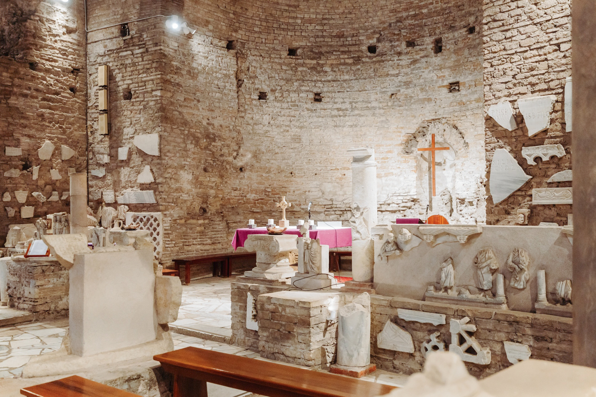 Underground Rome catacombs with ancient stone relics and altar on the Appian Way.