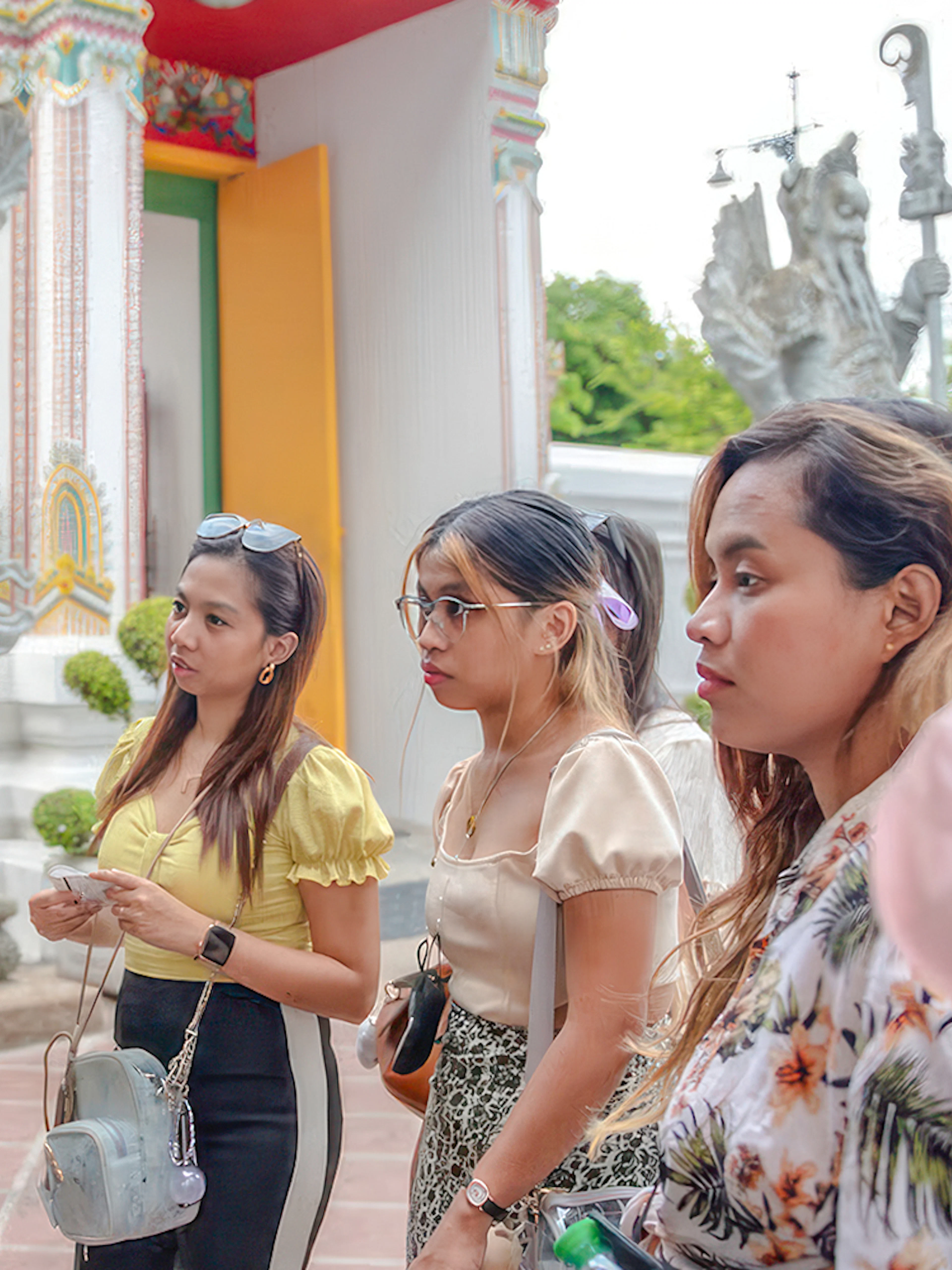 Tour guide explaining Wat Pho temple details to a group of visitors in Bangkok.