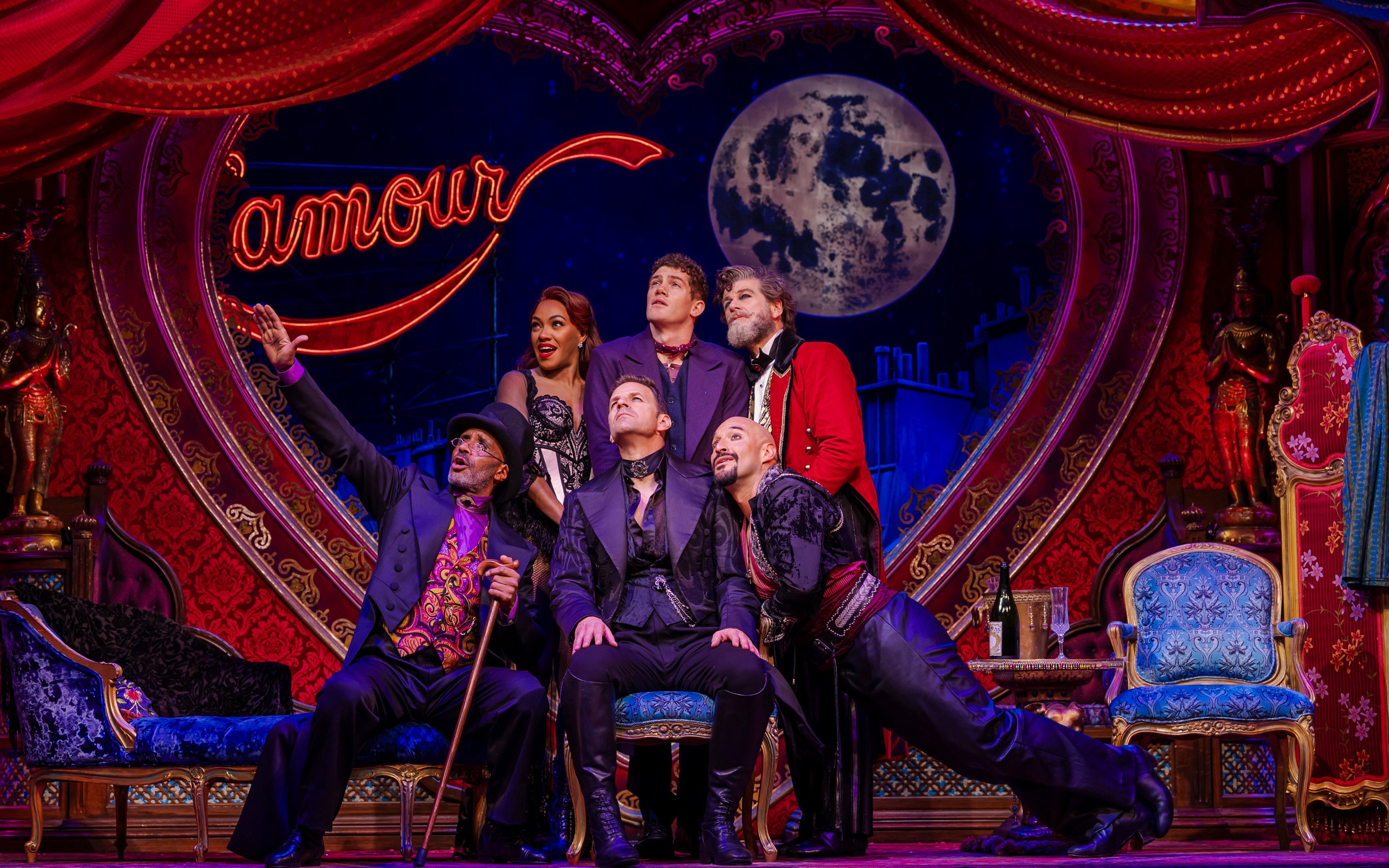 Stage performance of Come Alive Westend with actors in vibrant costumes under a moonlit backdrop.