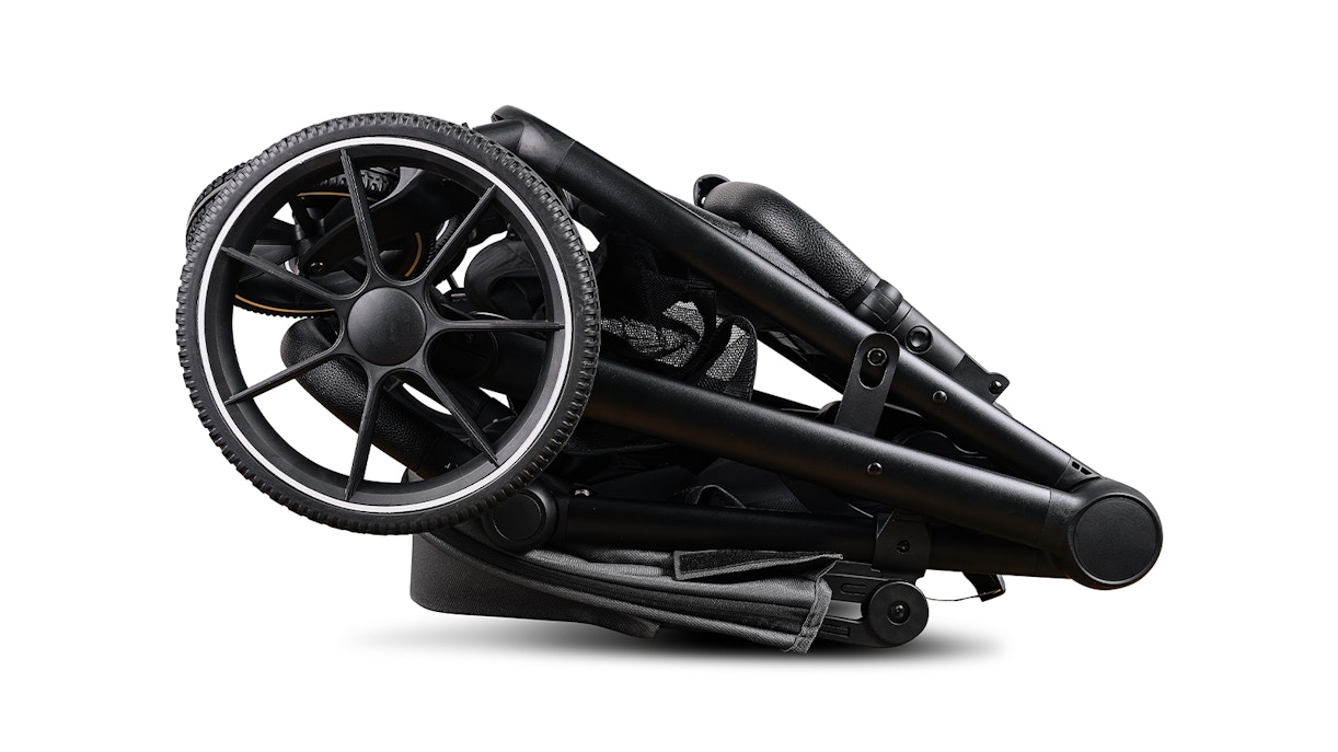 Folded baby stroller on white background.