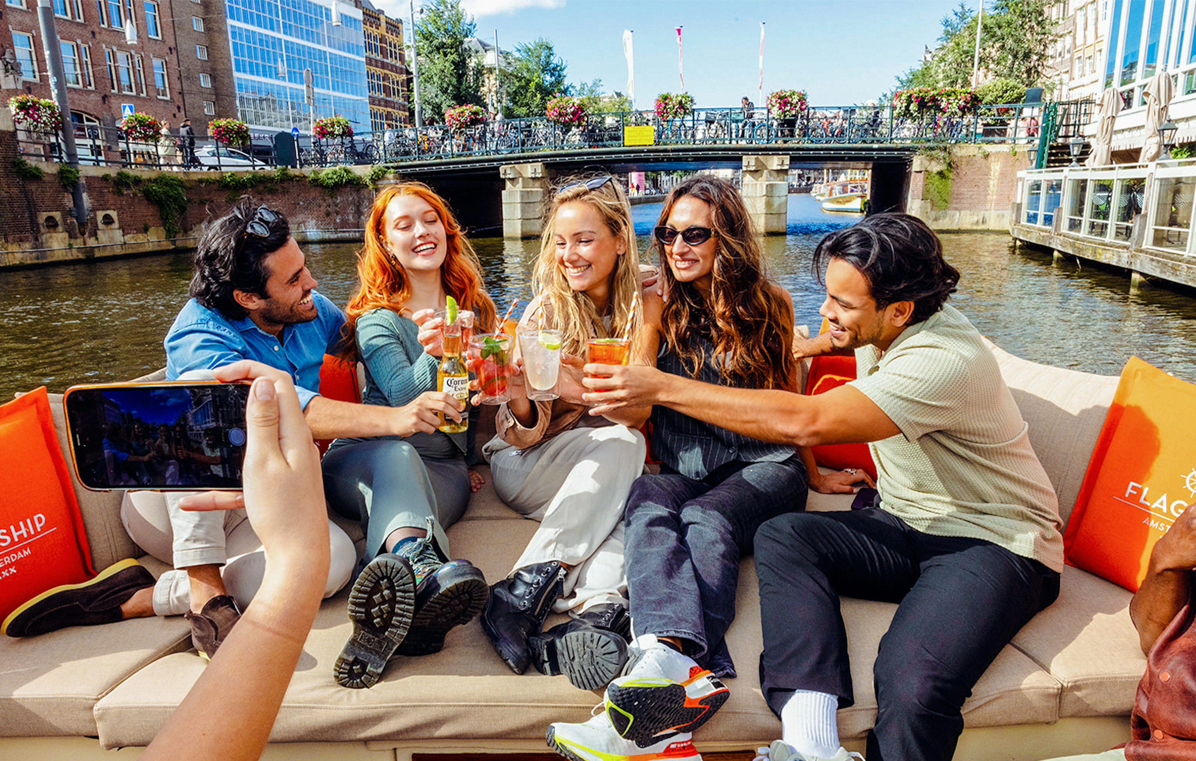 Tourists enjoying drinks on a canal cruise in Amsterdam.