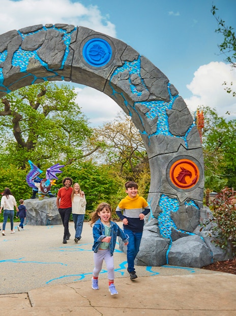 Entrance to LEGO MYTHICA at LEGOLAND® Windsor Resort with families walking through.