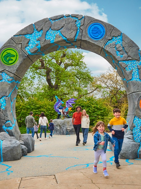 Entrance to LEGO MYTHICA at LEGOLAND® Windsor Resort with families walking through.
