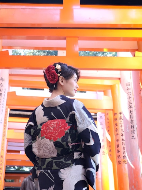 Person in kimono walking through torii gates at Fushimi Inari Shrine, Kyoto, Japan.