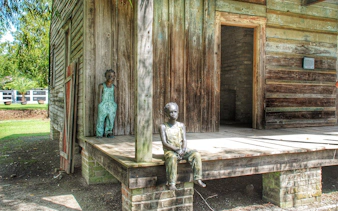 Statues of children on a wooden porch at Whitney Plantation, New Orleans.