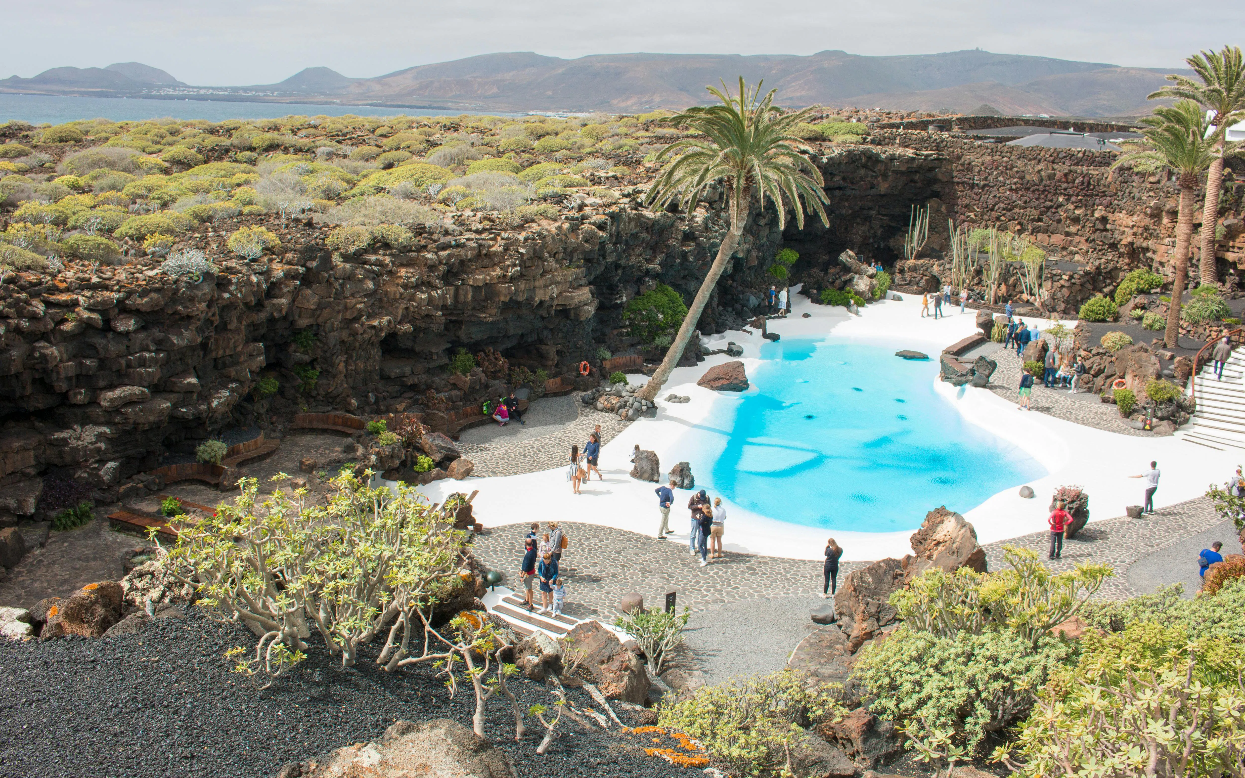 Jardín de Jameos del Agua in Lanzarote with turquoise pool and volcanic landscape.